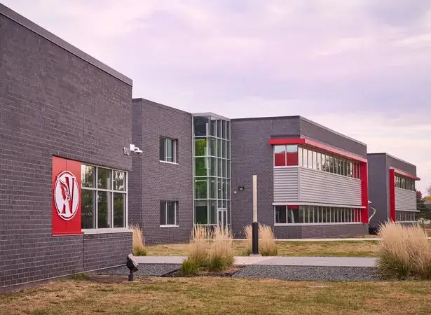 Modern school building with cardinal logo