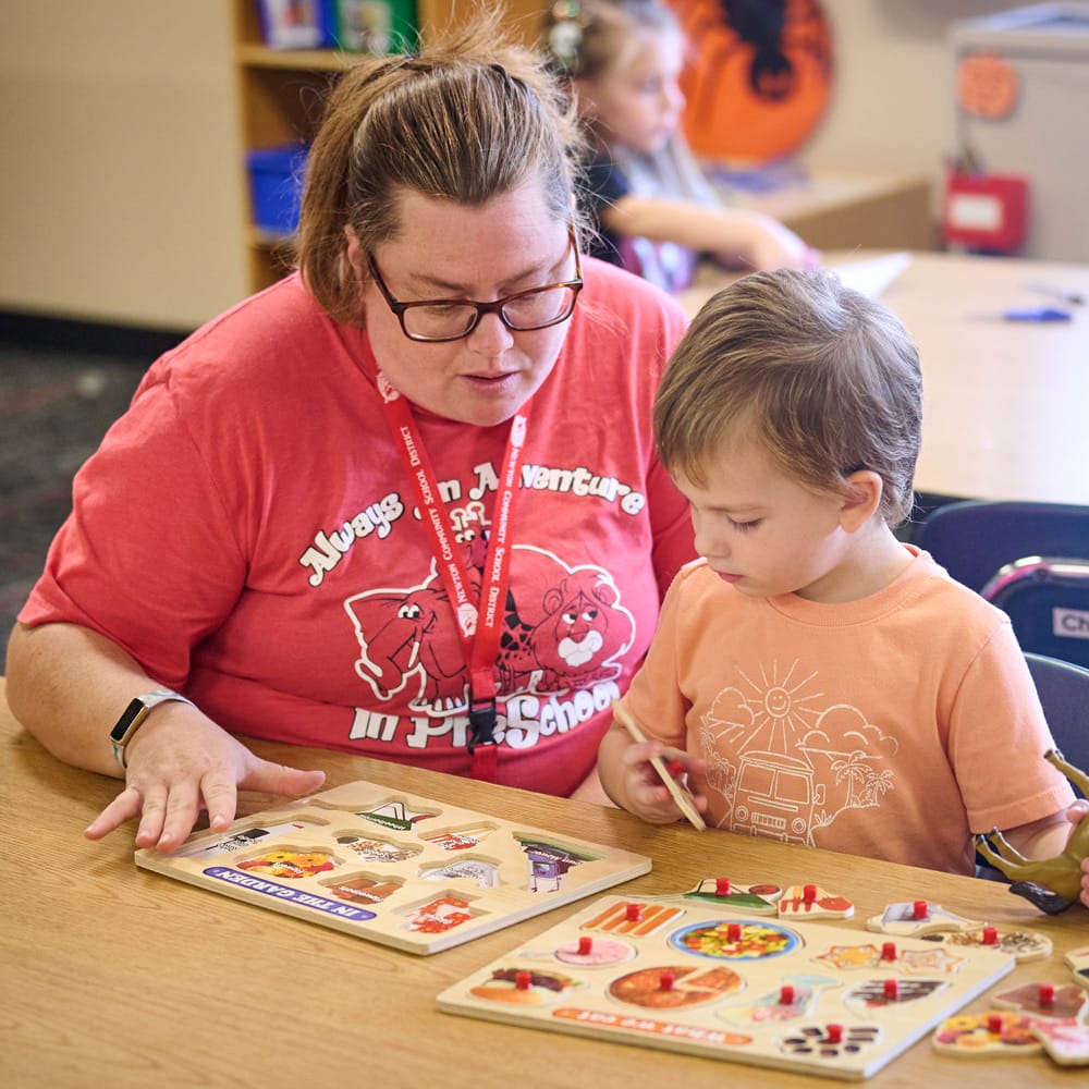 teacher helping child with puzzle