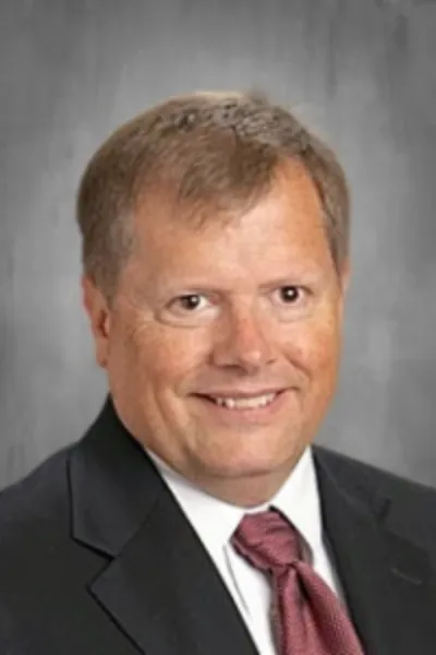 Man smiling at camera wearing professional clothing